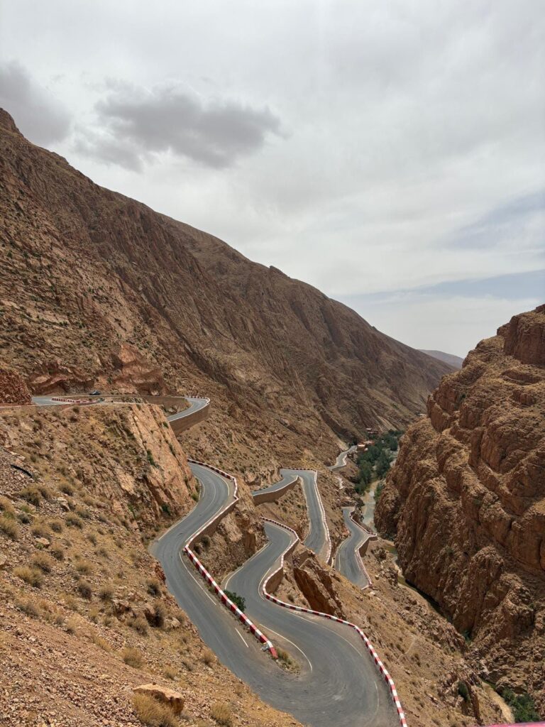 Hairpin bends of a mountain road with red-and-white barriers above a gorge